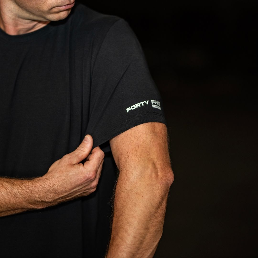 Person wearing a black t-shirt with 'Forty Five' logo on a dark background