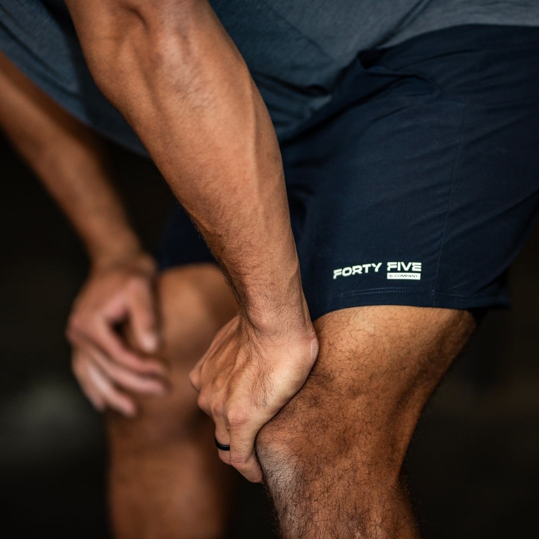 Person wearing navy shorts with 'Forty Five & Company' logo on a dark background