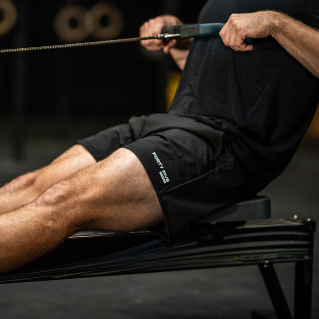 Person using a rowing machine in a gym setting