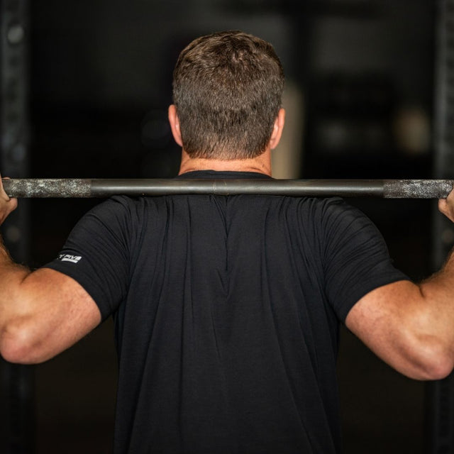 Man lifting a barbell in a gym setting