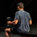 Man exercising with dumbbells in a gym setting