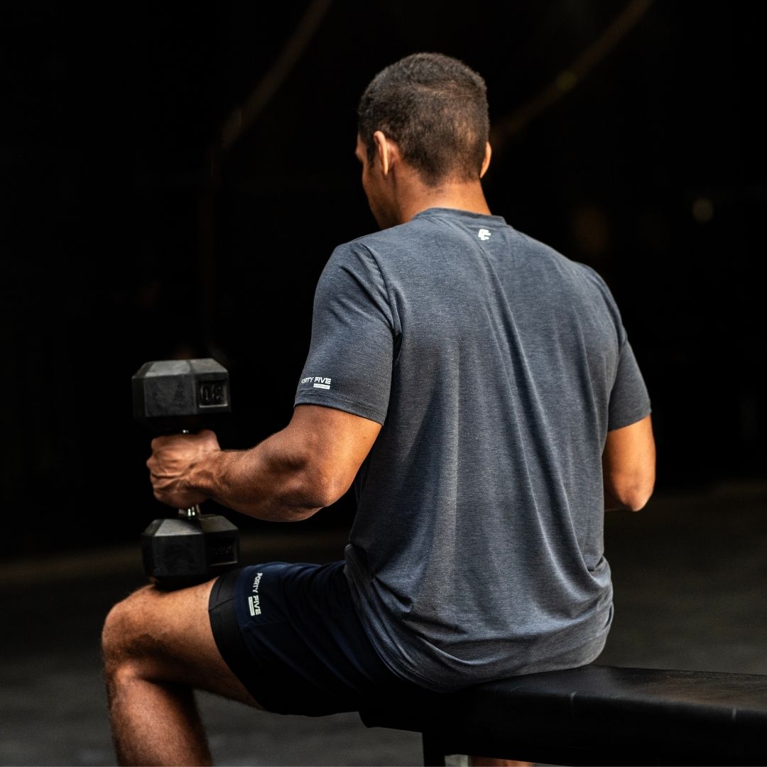 Man exercising with dumbbells in a gym setting