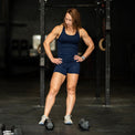Woman in athletic wear posing with dumbbells in a gym setting