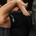 Person holding a hammer with a focus on the arm and black sleeve with 'Forty Five' branding.