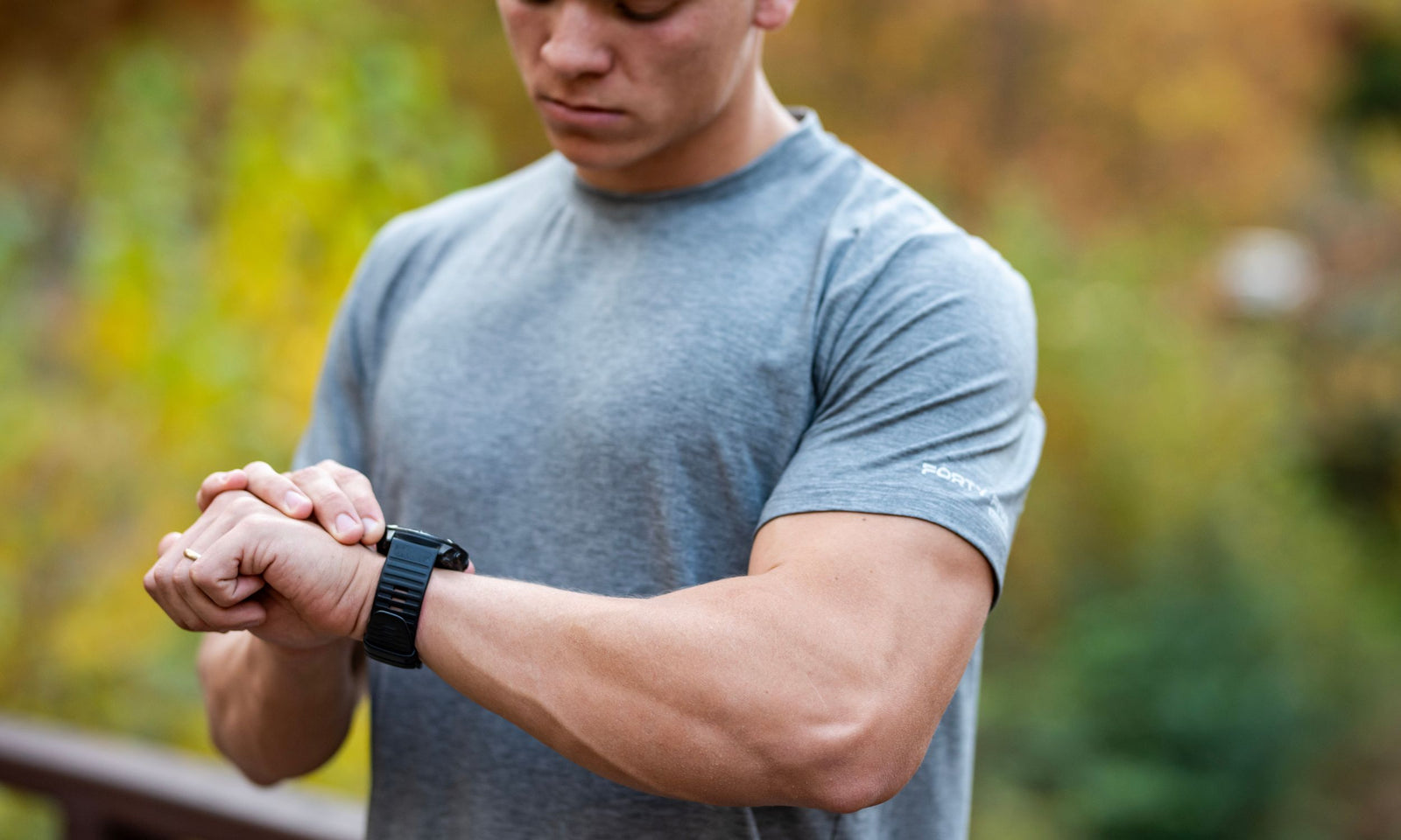 Man checking time on a smartwatch with a blurred natural background